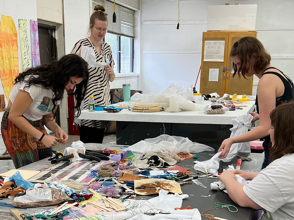 four young people working at an arts and crafts table