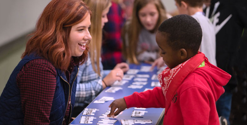 A student teacher working with a child at an elementary school