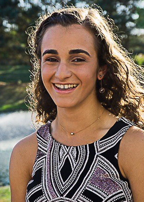 Headshot of girl in dark dress outside.