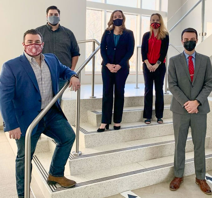 Four law students standing in a stairwell